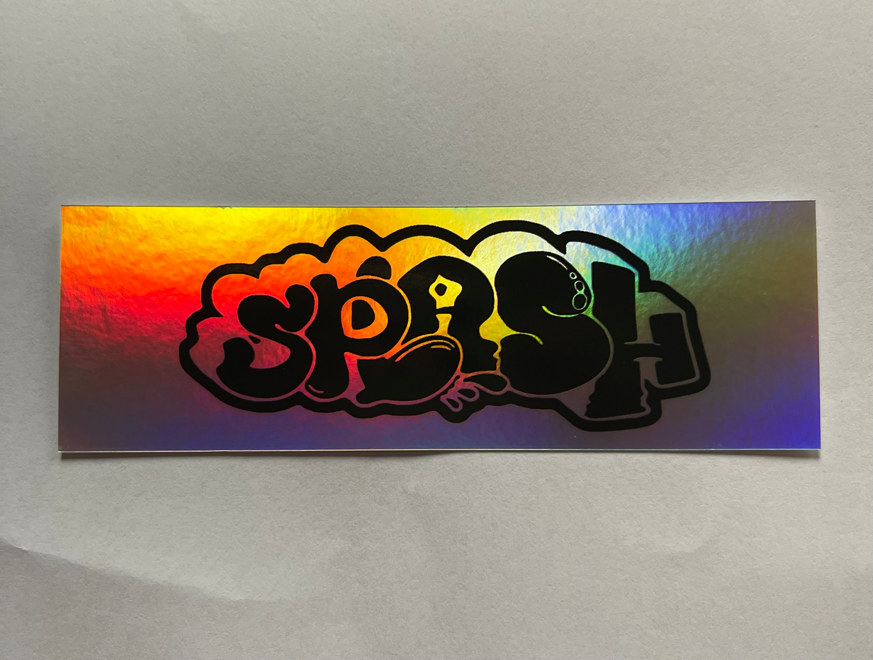 Graffiti Splash Tag Black ink on Mixed vinyl: half Silver Foil half Holographic
4.25 x 1.38" Rectangle Sticker